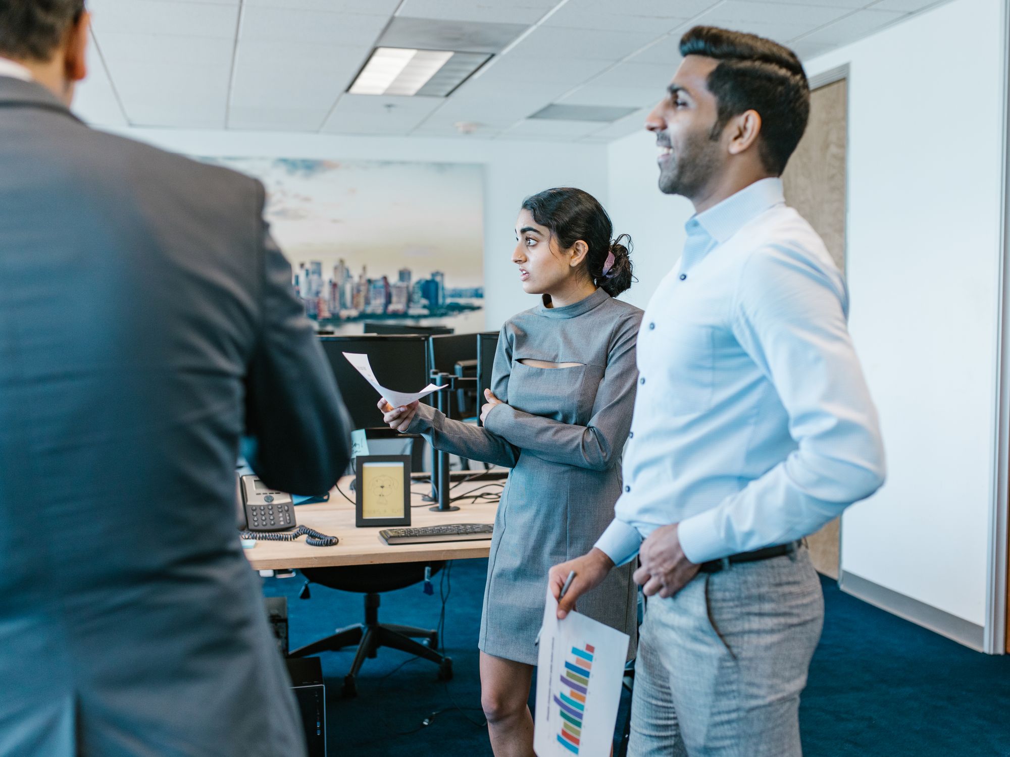 A small real-estate office team reviewing charts together